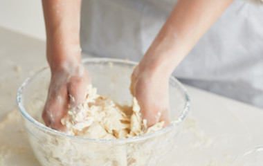 Obraz na płótnie Canvas woman hands mixing dough on wooden table