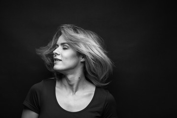 Dramatic black and white portrait of a beautiful woman on a dark background