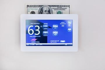 digital thermostat technology to heat or cool home for energy savings concept