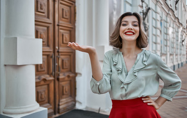 smiling woman holding a place on her hand free building street