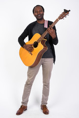 Full body shot of handsome African man playing the guitar