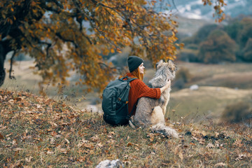 woman with a dog in the mountains in autumn