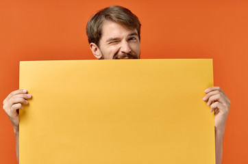 man with a beard holds yellow background