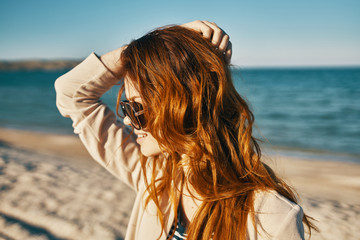 redhead woman with glasses on the sea nature sun