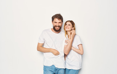 Naklejka premium young couple smiling in white t-shirts on an isolated background logo