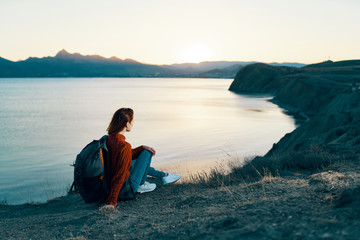 Fototapeta na wymiar woman sits on a cliff looks at the sea sky evening nature silence