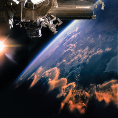 Spaceship on the orbit. Earth with clouds sunshine on the background. Elements of this image furnished by NASA.