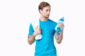 athlete man with a towel on his shoulder on an isolated background bottle of water