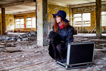 Girl in a black cloak and hat with a diplomat in a ruined room. A spy in a secret meeting. Unusual photo shoot