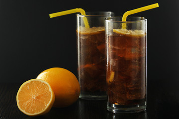Glasses with cuba libre cocktail or cola with ice or cold tea with lemon