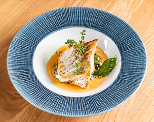 Fried fish fillet. Cod with sauce and herbs