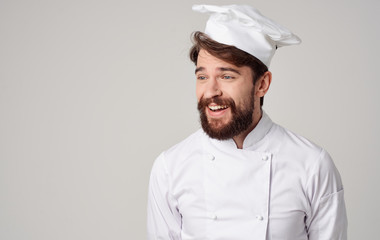 cook man with beard smiling on light background portrait kitchen