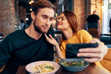 young couple having dinner in restaurant selfie