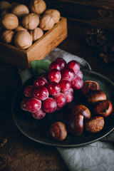Grapes and chestnuts on a wooden background