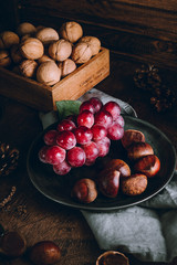 Grapes and chestnuts on a wooden background