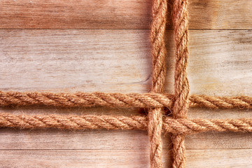 Twisted rope on a wooden textured background from an old plank.