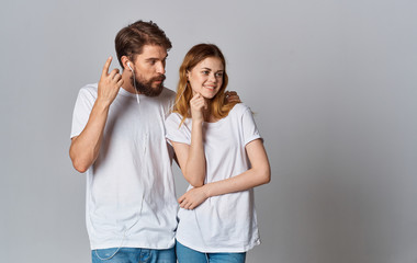 Naklejka premium young couple in white t-shirts with headphones