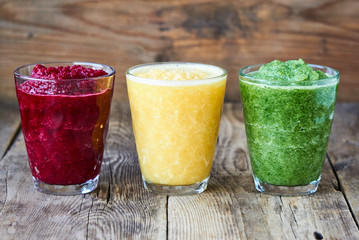 Colorful smoothies with beet, cucumber and orange on a wooden table       