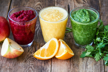 Colorful smoothies with beet, cucumber and orange on a wooden table       
