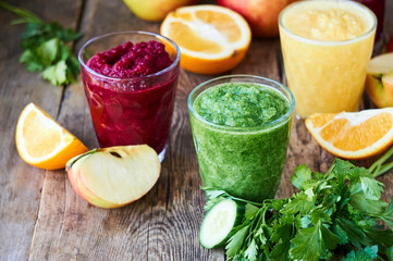 Colorful smoothies with beet, cucumber and orange on a wooden table       