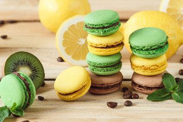 Green and yellow french macarons with kiwi, lemon and mint decorations