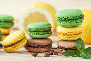 Green and yellow french macarons with kiwi, lemon and mint decorations