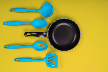 Kitchen utensils for cooking in kitchen isolated with copyspace on yellow background
