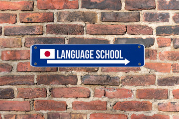 Fototapeta premium Ein Schild an der Wand weist auf die Sprachschule für japanische Sprache hin