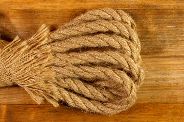 Natural fiber rope and fabric on a wooden textured background from an old plank.