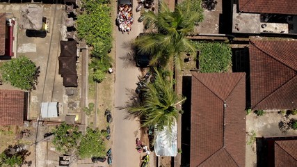 Fototapeta na wymiar 4K aerial flying video of balinese houses during the big celebration. Bali ceremony in village, Ubud. Roofs of balinese houses.