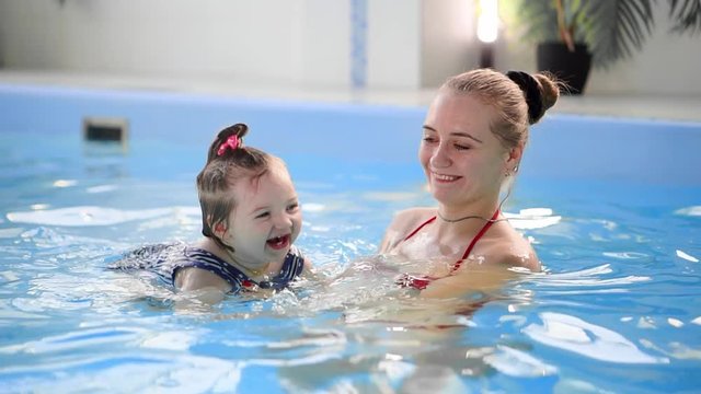 healthy family mother teaching baby swimming pool