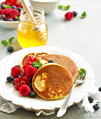 Breakfast - Cottage cheese pancakes,  curd fritters with raspberry, strawberry, blueberry.  Selective focu