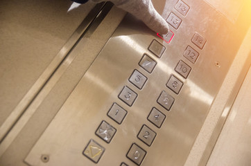 Hand presses the elevator button of the eleventh floor