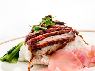 Roast Duck Rice. Popular Chinese barbecue rice dish of rice with slices of roast duck, thick sauce, and choy sum.