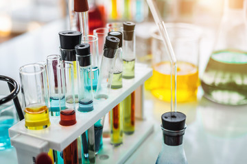 Lab glassware containing chemical liquid with laboratory background, science research and...