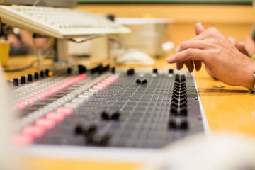 sound technician manipulating mixer in a radio station