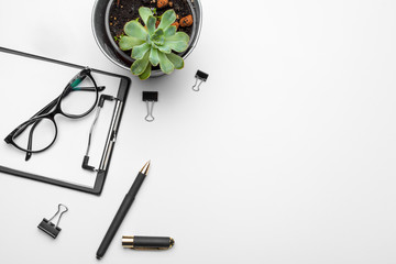 Home office workspace mockup with  green plant and stationery accessories with copy space background. Flat lay, top view
