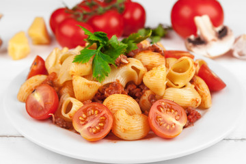 Pasta with meat, tomato sauce and vegetables on the table