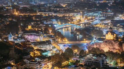 Tbilisi, Georgia. Top View Of Famous Landmarks In Evening Or Night Illuminations. Georgian Capital Skyline Cityscape