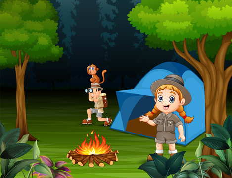 Happy children camping out in a forest