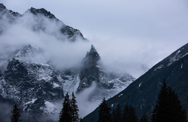 mountains in winter with low clouds