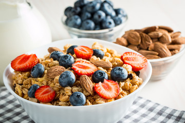 Healthy breakfast concept with oat flakes and fresh berries on rustic background. Food made of granola and muesli. Healthy banana smoothie with blackberries, honey and milk.