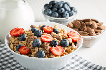 Healthy breakfast concept with oat flakes and fresh berries on rustic background. Food made of granola and muesli. Healthy banana smoothie with blackberries, honey and milk.