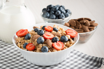 Healthy breakfast concept with oat flakes and fresh berries on rustic background. Food made of granola and muesli. Healthy banana smoothie with blackberries, honey and milk.