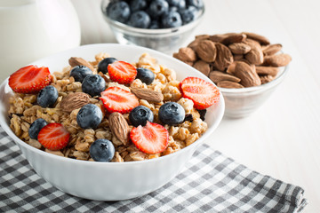 Healthy breakfast concept with oat flakes and fresh berries on rustic background. Food made of granola and muesli. Healthy banana smoothie with blackberries, honey and milk.