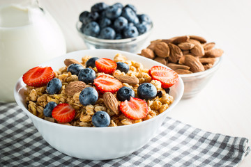 Healthy breakfast concept with oat flakes and fresh berries on rustic background. Food made of granola and muesli. Healthy banana smoothie with blackberries, honey and milk.