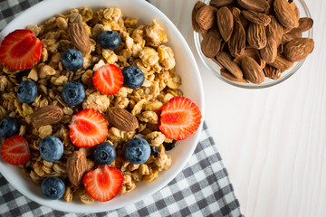 Healthy breakfast concept with oat flakes and fresh berries on rustic background. Food made of granola and muesli. Healthy banana smoothie with blackberries, honey and milk.