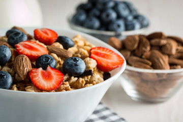 Healthy breakfast concept with oat flakes and fresh berries on rustic background. Food made of granola and muesli. Healthy banana smoothie with blackberries, honey and milk.