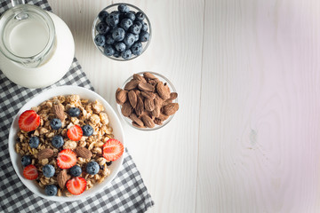 Healthy breakfast concept with oat flakes and fresh berries on rustic background. Food made of granola and muesli. Healthy banana smoothie with blackberries, honey and milk.