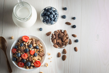 Healthy breakfast concept with oat flakes and fresh berries on rustic background. Food made of granola and muesli. Healthy banana smoothie with blackberries, honey and milk.
